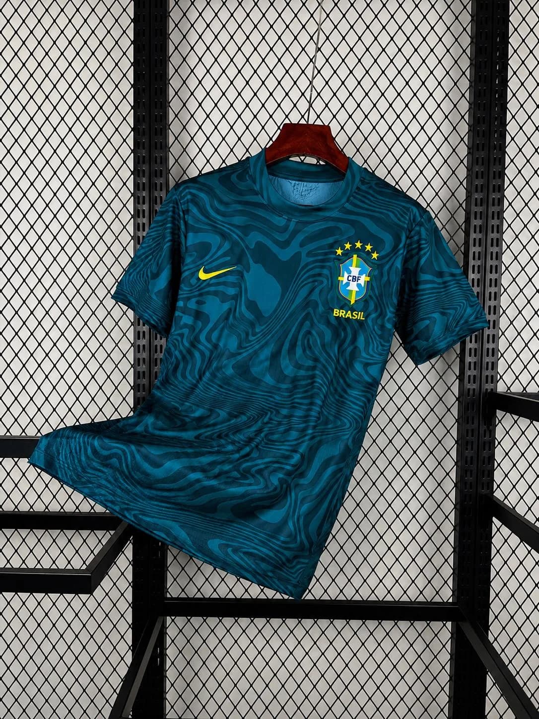 Maillot du Brésil turquoise pétrole sur cintre, motif de vagues sombres et inscription BRASIL jaune