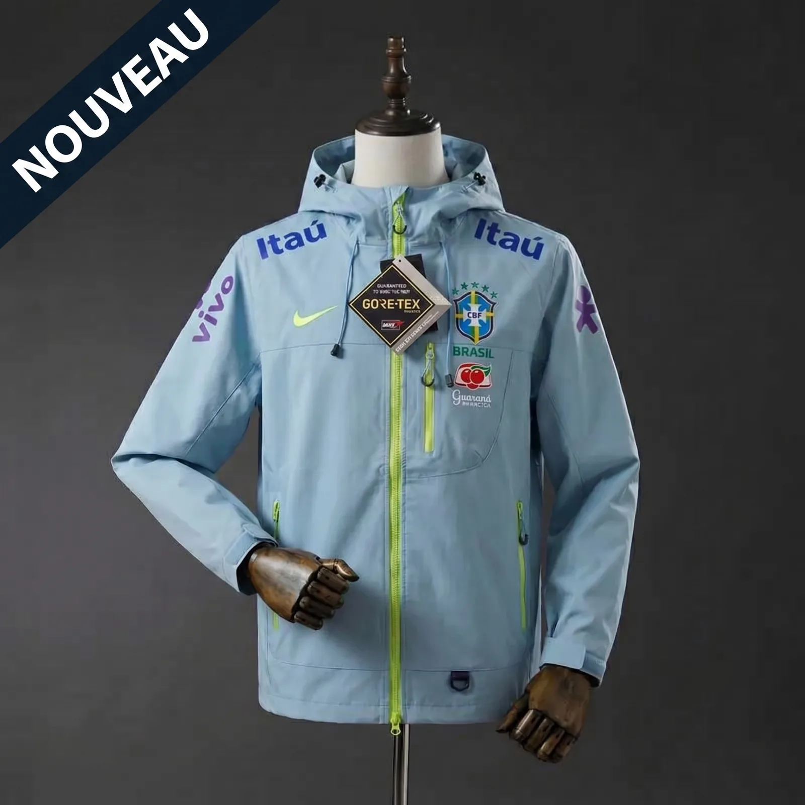 Veste du Brésil bleu ciel de face sur mannequin, zips vert fluo, capuche et poches zippées